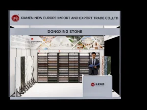 Dongxing Group (DONGXING STONE) exhibition booth at MosBuild 2026 in Moscow, featuring terrazzo artificial stone and natural stone samples, company logo, and professional reception area for building materials industry visitors