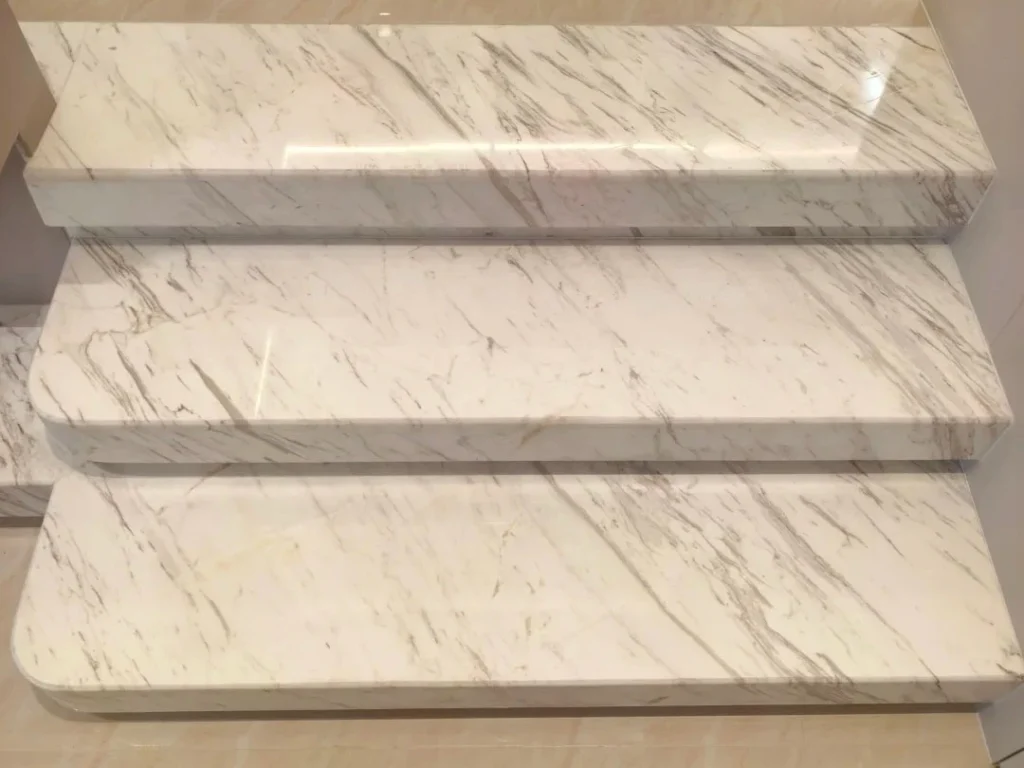 Clean white marble staircase after we remove yellow stains on marble, showing a bright, restored surface free of discoloration