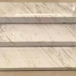 Clean white marble staircase after we remove yellow stains on marble, showing a bright, restored surface free of discoloration