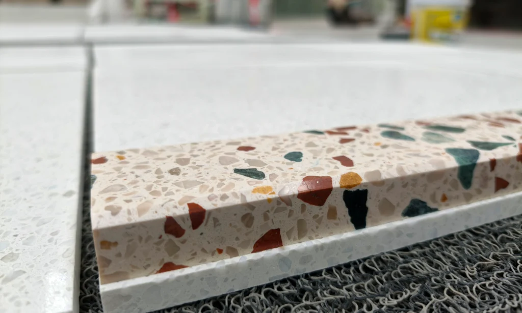 Close-up cross section of thick cement terrazzo slab, clear natural stone aggregate distribution inside